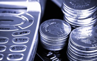silver coins next to mobile phone buttons