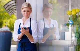 waitress standing outdoors holding a card reader