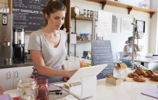 woman using an iPad point of sale system in a cafe