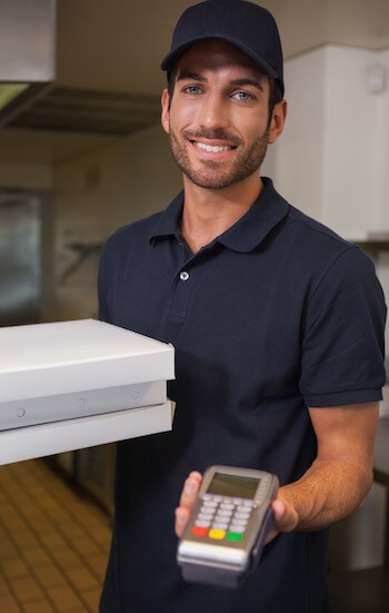 pizza delivery man holding a PDQ terminal