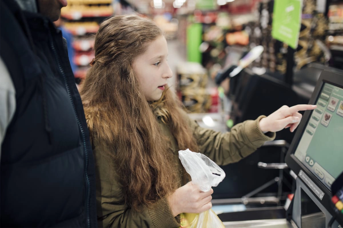 girl at a supermarket self-service checkout