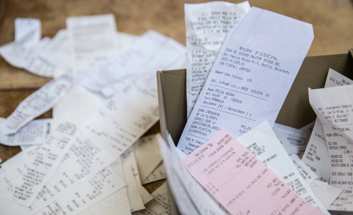 Messy paper receipts in and around a box