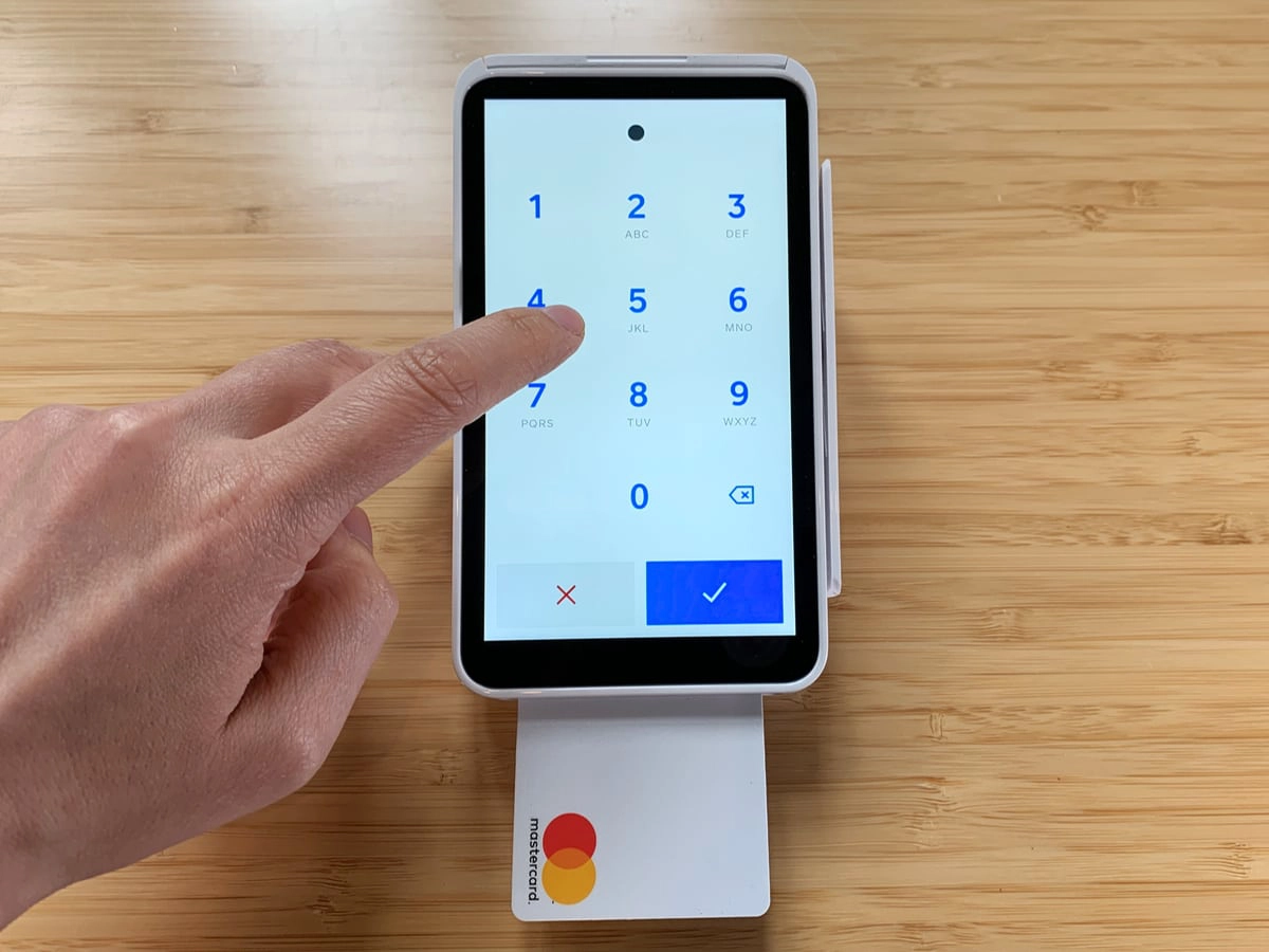 hand entering PIN on Square Terminal