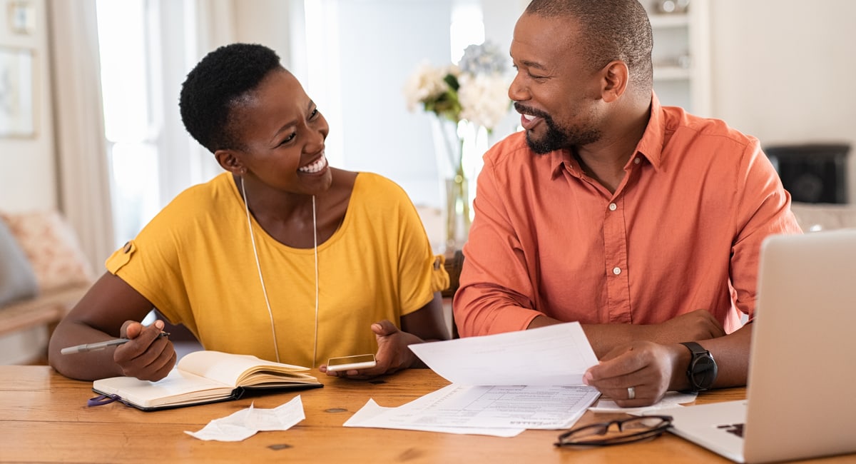 smiling couple looking at finances